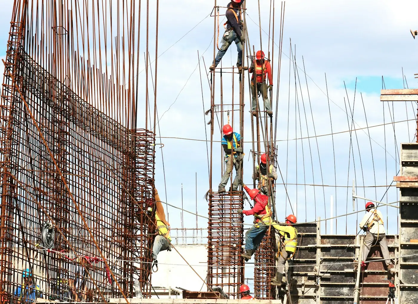 Construction crew fixing steel reinforcement on a building column