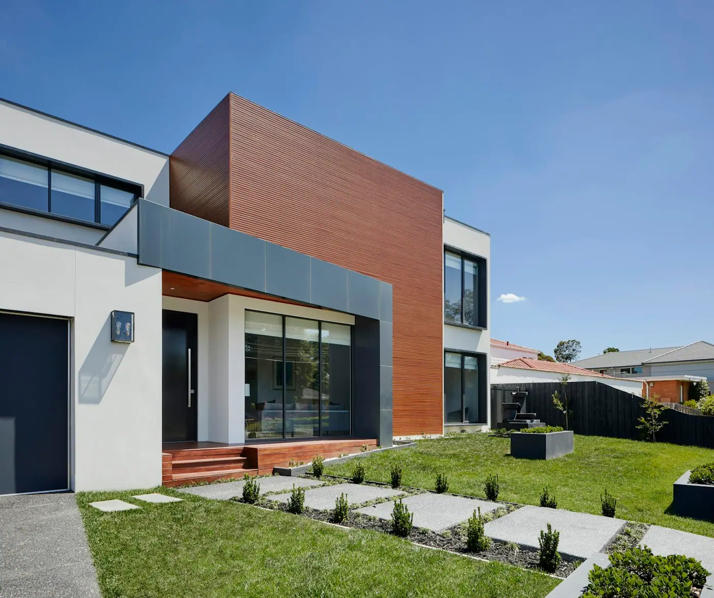 House facade with timber cladding and landscaped lawn