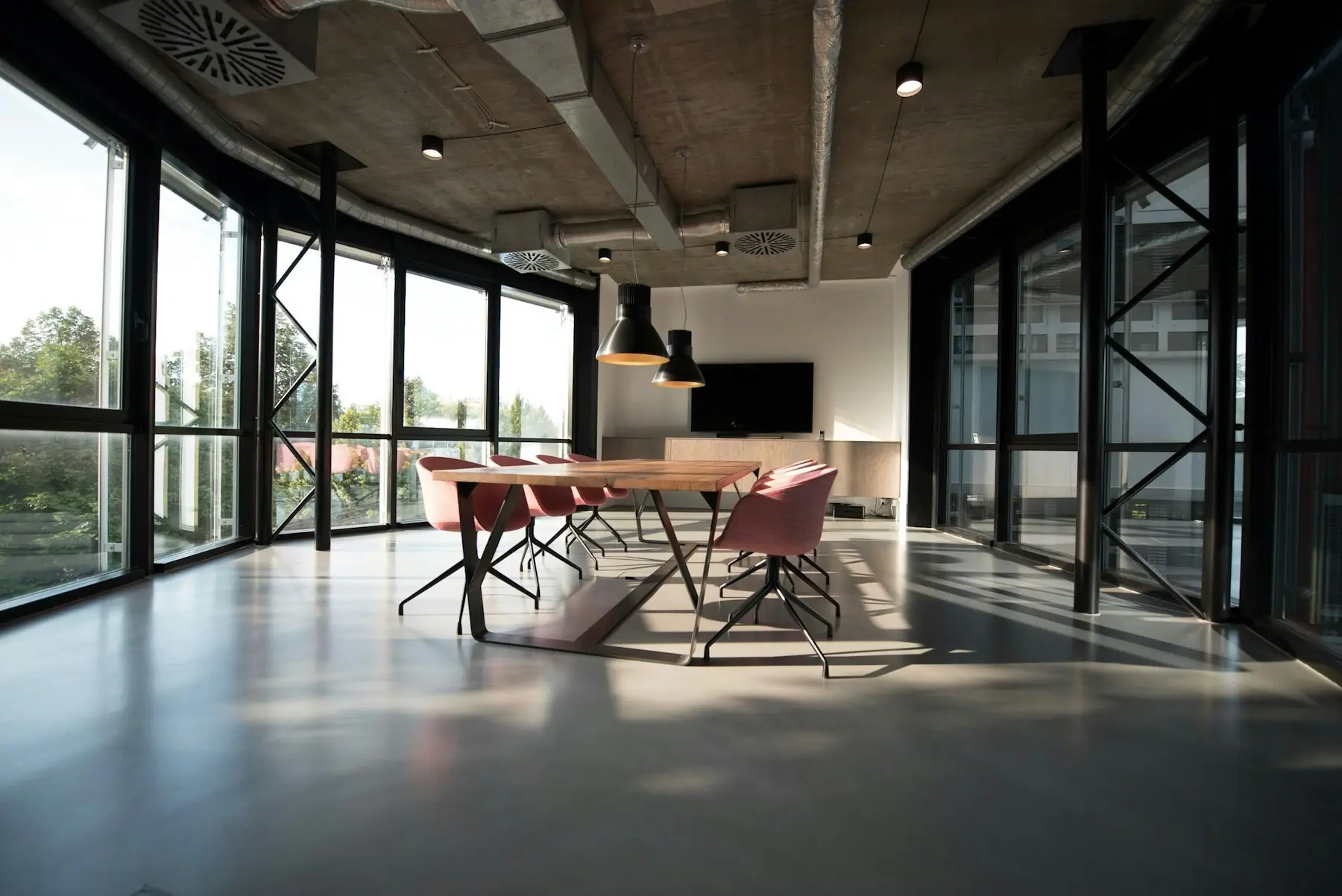 Bright open-plan office with glazed walls and meeting table